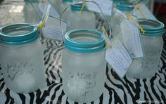 there are many mason jars on the table with tags attached to them and labels in each jar