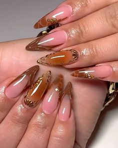 a woman's hands with long, shiny nails and gold decorations on their fingers