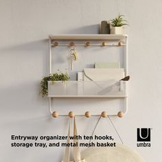 a wall shelf with hooks, storage trays and metal mesh basket hanging from it