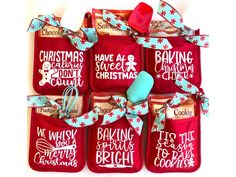 red oven mitts decorated with christmas sayings and blue ribbon tied around the handles