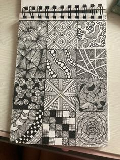 a spiral notebook with black and white designs on it