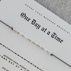 Remind yourself or someone you love with the words "ONE DAY AT A TIME" in a secret Morse code message bracelet they can keep close to them on their wrist.   🖤 Dainty and subtle, "ONE DAY AT A TIME"  is spelled out in Morse code alphabet using high quality .925 Sterling silver, 14 karat gold fill, rose gold, or 14 karat solid gold beads. 🖤 Band is made from durable, high quality 100% silk cord in your choice of color. 🖤 End beads and closure bead are coordinating sterling silver or 14 Karat go Morse Code Alphabet, Code Alphabet, Morse Code Jewelry, Coded Message