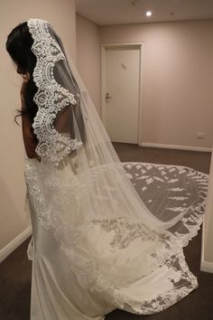 a woman in a wedding dress looking at her veil