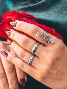 a woman's hand with two rings on it and a flower in the middle