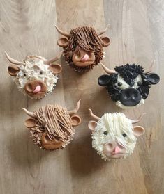 cupcakes made to look like farm animals are sitting on a wooden table top