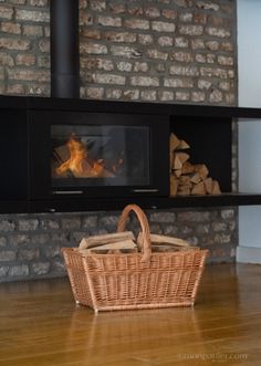 a basket sitting on the floor in front of a fireplace