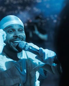 a man holding a microphone up to his ear while wearing a head band and talking on the phone