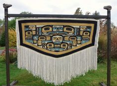 a decorative wall hanging with native art on it's sides and fringes around the edges