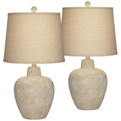 two white ceramic lamps with beige shades on each lamp and one is turned off to the side