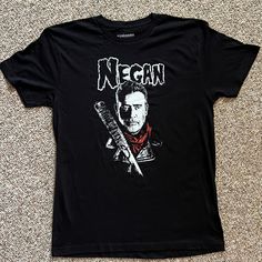 a black t - shirt with an image of a man holding a knife on it