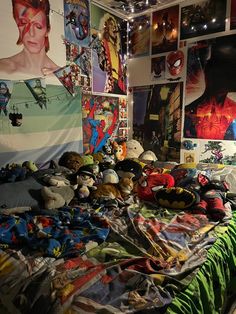 a bed covered in lots of stuffed animals next to a wall with pictures on it