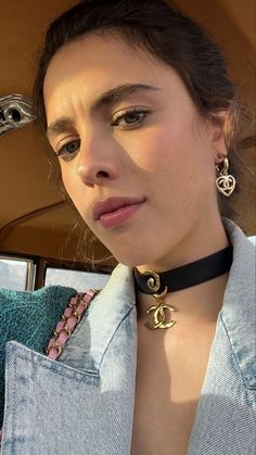 a woman in a car wearing a black choker and matching necklace with an earring