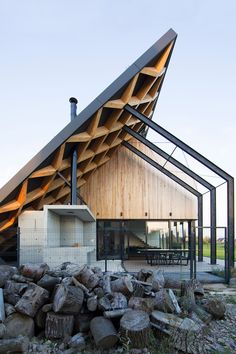 an unusual house made out of wood and metal with a roof that has been folded over it