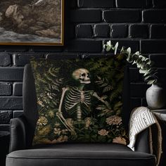 a pillow with a skeleton on it sitting in front of a brick wall next to a chair