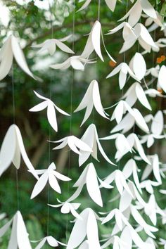 some white paper birds hanging from a tree