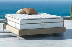 a mattress sitting on top of a table next to the ocean