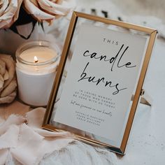 there is a candle and some flowers on the table next to a sign that says candles burns