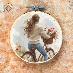 a woman riding a bike with flowers in the basket on her hand and holding a teddy bear