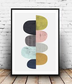 an art print with different colors and shapes on the wall next to a brick wall