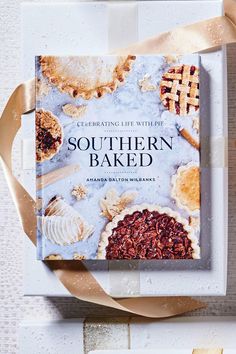 the book southern baked is sitting on top of a white plate with ribbon around it