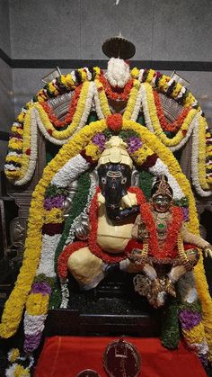 the statue is decorated with flowers and garlands