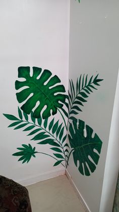 a room with some green leaves painted on the wall