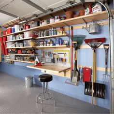 a garage with shelves filled with tools and other items on the wall, along with two stools