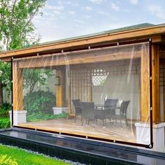 a covered patio with table and chairs in the back ground, surrounded by grass and trees