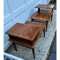 three wooden tables sitting next to each other in front of a garage door