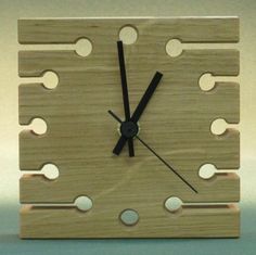 a clock made out of wood with holes in the middle and black numbers on each side