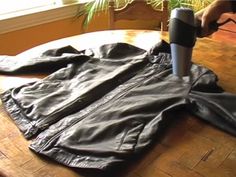 a pair of black pants sitting on top of a wooden table