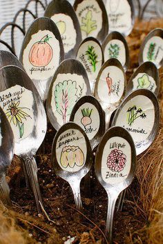 many spoons with different designs on them are in the dirt next to some grass