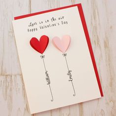 two hearts are attached to a card with the words love as in the year happy valentine's day