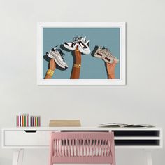 three pairs of shoes are hanging on the wall above a desk with a pink chair