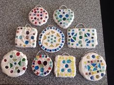 nine pieces of mosaic tile sitting on top of a granite counter next to each other