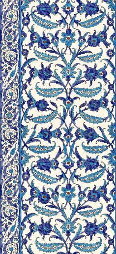 an intricately designed rug with blue and white designs on the border, in front of a