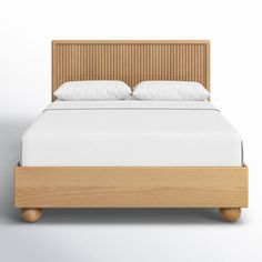 a bed with white sheets and wooden headboard