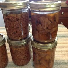 four jars filled with cookies sitting on top of a table