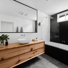 a bathroom with a sink, mirror and bathtub next to a walk in shower