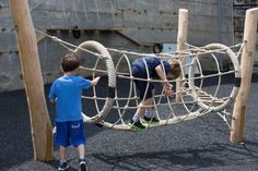 two young boys playing in a rope playground