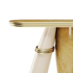 a close up of a cup on a table with a gold handle and two white cups