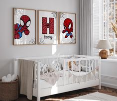 a baby's room with two spider - man posters on the wall and a crib