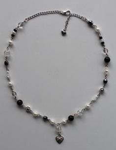 a white and black beaded necklace with a heart charm