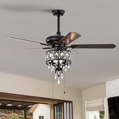 a living room with a ceiling fan and chandelier hanging from it's ceiling