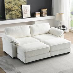 a white couch sitting on top of a rug in a living room next to a window