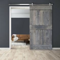 an open sliding door in a living room with grey walls and hardwood floors, along with a brown couch