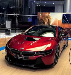 a red sports car is on display in a showroom