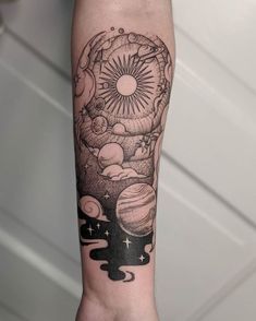 a person's arm with a black and white tattoo design on it, including planets