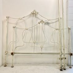 a white metal bed frame in a room