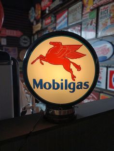 a lighted mobbilgas sign sitting on top of a counter